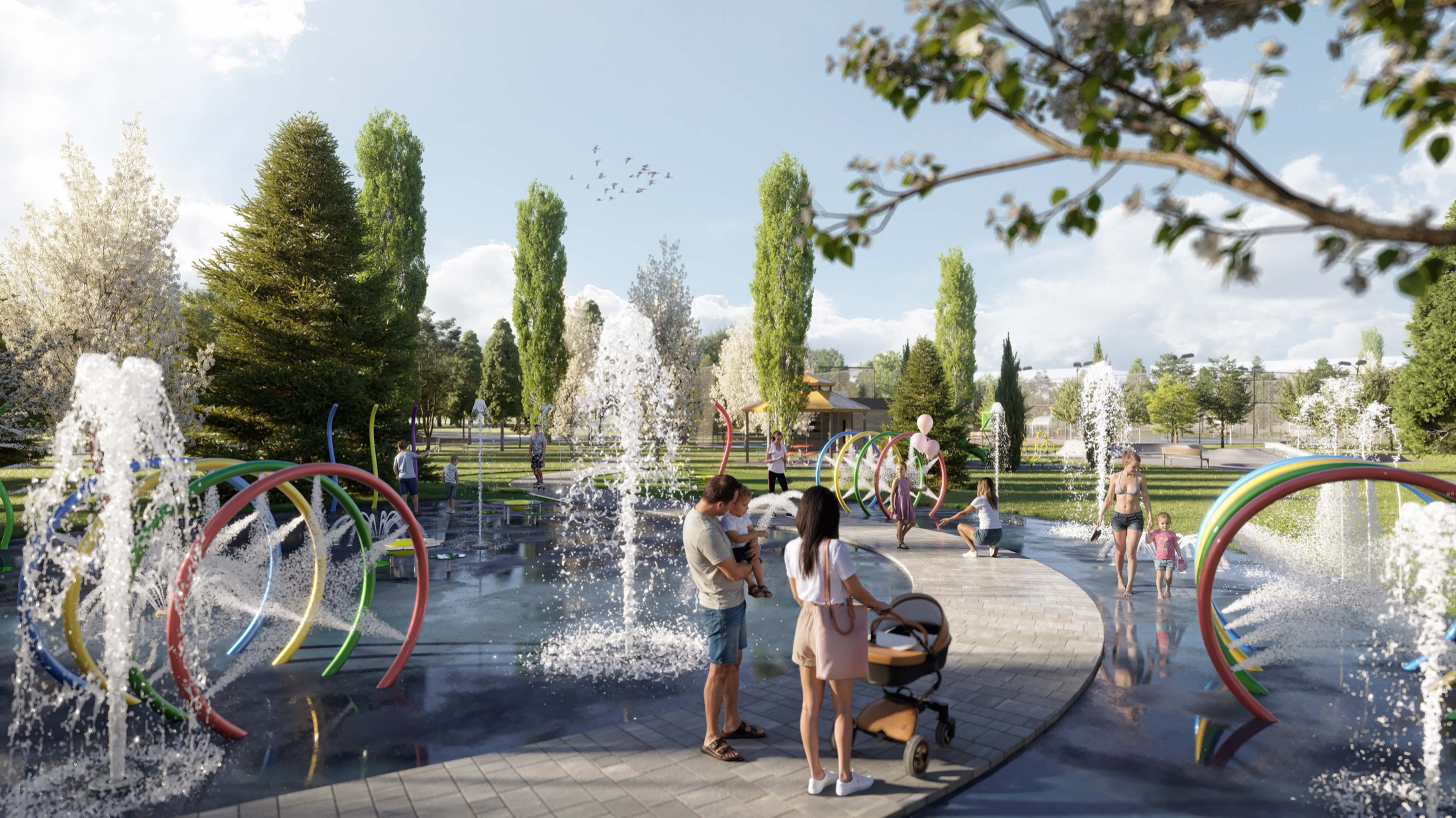 Families at the splash pad and water-play gardens at golden hour
